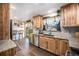 Well-lit kitchen featuring granite countertops, a stainless dishwasher, and natural wood cabinets at 7071 Beach St, Westminster, CO 80030