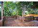 Exterior view of a wooden deck with a lattice railing, surrounded by lush trees and greenery at 17657 E Prentice Cir, Aurora, CO 80015