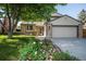 Charming two-story home with a well-manicured lawn and a lovely flower garden in front at 17657 E Prentice Cir, Aurora, CO 80015