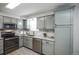 Well-lit kitchen featuring gray cabinets, granite countertops, and stainless steel appliances at 17657 E Prentice Cir, Aurora, CO 80015