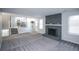 Open-concept living room with brick fireplace, carpet flooring, and view of kitchen at 17657 E Prentice Cir, Aurora, CO 80015