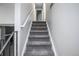 Carpeted staircase leads to the upper level, offering a seamless transition between floors at 17657 E Prentice Cir, Aurora, CO 80015