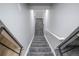 Carpeted staircase with a modern handrail leading to lower level at 17657 E Prentice Cir, Aurora, CO 80015