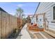 Backyard area with garden beds and mature landscaping, featuring a concrete walkway at 935 Newark St, Aurora, CO 80010