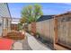 Backyard garden featuring raised garden beds, mature trees, and a concrete walkway at 935 Newark St, Aurora, CO 80010