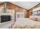 Bedroom with wood plank accent walls, fireplace, and French doors leading to outdoor space at 935 Newark St, Aurora, CO 80010