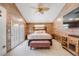 Vaulted ceiling bedroom with wood plank accent walls, ceiling fan, and light filled French doors at 935 Newark St, Aurora, CO 80010