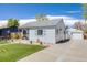 Single-story house with a long driveway, a well-manicured lawn and detached garage at 935 Newark St, Aurora, CO 80010