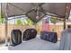 Covered outdoor patio with BBQ grills, American flag, and wood fence surround at 935 Newark St, Aurora, CO 80010