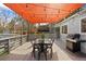 Inviting back deck area with outdoor dining set, overhead shade cover, and grill at 1180 S Honey Way, Denver, CO 80224