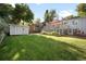 Spacious backyard with lush green lawn, storage shed, and a charming deck at 1180 S Honey Way, Denver, CO 80224
