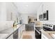 Bright kitchen with white cabinets, bar seating, and stainless steel appliances at 1180 S Honey Way, Denver, CO 80224