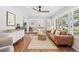 Bright living room featuring hardwood floors, large windows with shutter blinds, and an open floor plan at 1180 S Honey Way, Denver, CO 80224