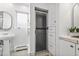 Bright bathroom featuring pedestal sink, tiled shower, and built-in storage cabinets at 229 Albion St, Denver, CO 80220