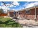 Brick home featuring a stone patio, outdoor dining set and grill at 6676 S Kit Carson St, Centennial, CO 80121