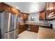 Functional kitchen with stainless steel appliances, ample cabinet space, and tile flooring for easy maintenance at 6676 S Kit Carson St, Centennial, CO 80121