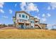 Expansive backyard view of a modern two-story home featuring dual walkout balconies and pristine landscaping at 16272 W 95Th Ln, Arvada, CO 80007