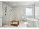 Bright bathroom featuring white tiled walls and a free-standing soaking tub at 16272 W 95Th Ln, Arvada, CO 80007