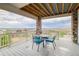 Covered deck with table and chairs, offering scenic views at 16272 W 95Th Ln, Arvada, CO 80007