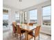 Bright dining room featuring a modern chandelier, wood table, and large windows with a beautiful view at 16272 W 95Th Ln, Arvada, CO 80007