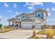 Two-story home with a stone and siding exterior, three-car garage, well-manicured front lawn, and for sale sign at 16272 W 95Th Ln, Arvada, CO 80007