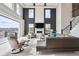 Bright living room features high ceilings, a fireplace with a TV, large windows, and modern furnishings at 16272 W 95Th Ln, Arvada, CO 80007