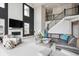 Bright living room features high ceilings, fireplace with TV, large windows, a staircase, and neutral decor at 16272 W 95Th Ln, Arvada, CO 80007
