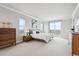 Bright main bedroom boasts a balcony, tray ceiling, and serene views of the nearby water feature at 16272 W 95Th Ln, Arvada, CO 80007