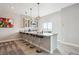 Basement wet bar with pendant lighting, a marble countertop, seating for five, and display cabinets at 16272 W 95Th Ln, Arvada, CO 80007