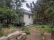 Backyard view with a white garage, trees and a path at 4209 Perry St, Denver, CO 80212