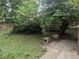 Shady backyard with trees, plants, concrete patio and brick lined walkway at 4209 Perry St, Denver, CO 80212