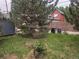 Backyard view with grass, trees, trash bins and a view of a house in the background at 4209 Perry St, Denver, CO 80212