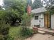 Backyard with lush greenery, patio with bench and a brick chimney at 4209 Perry St, Denver, CO 80212