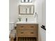 Modern bathroom featuring a wood vanity with drawers, a framed mirror, a sleek faucet, and a white toilet at 6330 E Irwin Pl, Centennial, CO 80112