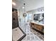 Modern bathroom with a walk-in shower, decorative tile, wooden vanity, and a sleek mirror and lighting at 6330 E Irwin Pl, Centennial, CO 80112