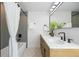 Modern bathroom with dual sinks, sleek fixtures, and a shower-tub combination with a decorative shower curtain at 6330 E Irwin Pl, Centennial, CO 80112