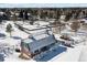 View of the community pool, clubhouse, tennis courts, and playground covered in snow, surrounded by evergreen trees at 6330 E Irwin Pl, Centennial, CO 80112