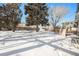 Snowy backyard with mature trees and a deck at 1859 S Saulsbury Ct, Lakewood, CO 80232