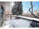 Snow covered deck with table and chairs, overlooking backyard at 1859 S Saulsbury Ct, Lakewood, CO 80232