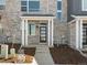 Welcoming front entrance featuring a modern black door, white pillars, and tidy landscaping at 22360 E 8Th Ave, Aurora, CO 80018