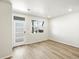 Bright, spacious living room features wood-look flooring, a window, and a modern front door at 22360 E 8Th Ave, Aurora, CO 80018