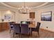 Cozy dining room with a wooden table, upholstered chairs, and a modern chandelier at 4822 Bandera Pl, Parker, CO 80134