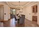 Dining room with a tray ceiling, chandelier, wood floors, and a view into a butler's pantry at 4822 Bandera Pl, Parker, CO 80134