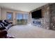 Modern living room featuring a stone fireplace, large TV, and a comfortable seating area with a view at 4822 Bandera Pl, Parker, CO 80134