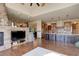 Open-concept living area leading to the kitchen, featuring a stone fireplace and comfortable seating at 4822 Bandera Pl, Parker, CO 80134