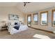 Bright main bedroom featuring an ensuite, large windows with scenic views, and a stylish tray with a blue blanket at 4822 Bandera Pl, Parker, CO 80134