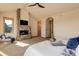 Spacious main bedroom showcasing a cozy fireplace, large television, and access to ensuite at 4822 Bandera Pl, Parker, CO 80134
