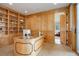 Stylish office with custom shelving, wood paneling, and glass desk transitions seamlessly to the cozy living room at 4822 Bandera Pl, Parker, CO 80134