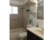 This bathroom features tile surround shower over tub, updated vanity, mirror, and decor at 5640 E 67Th Pl, Commerce City, CO 80022