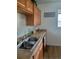 This kitchen features a stainless steel sink, warm wood cabinets, and a neutral countertop finish at 5640 E 67Th Pl, Commerce City, CO 80022